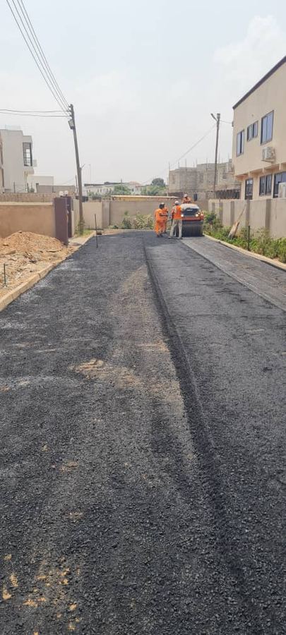 Worker paving a road with fresh asphalt